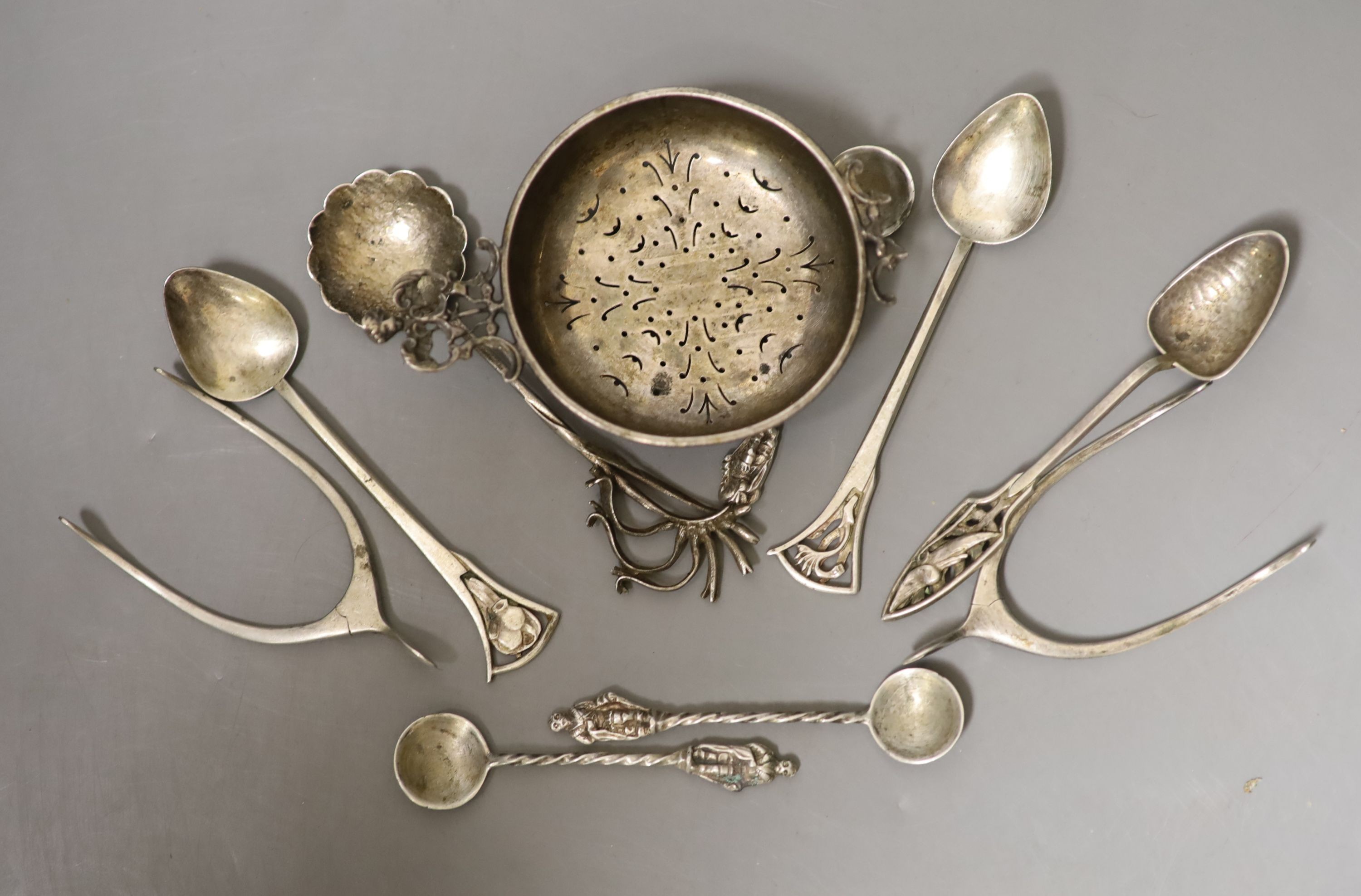 Small silver including two pairs of silver wishbone sugar nips, Levi & Salaman, Birmingham, 1922, a silver tea strainer and assorted spoons.